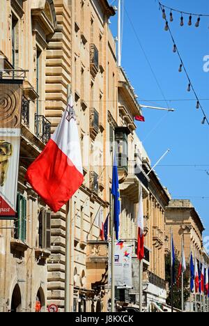 EU und Malteser Fahnen und Gebäude entlang der Republic Street aka Triq Ir Repubblika, Valletta, Malta, Europa. Stockfoto