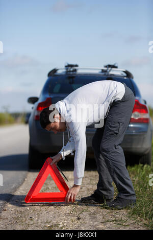 Junge Brünette setzen rotes Dreieck Stockfoto