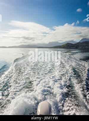 Die Wellen und Spritzwasser von der Rückseite eines Bootes Beschleunigung über das blaue Wasser der Kaneohe Bay auf Oahu, Hawaii gesehen. Stockfoto