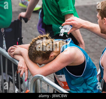 Ein Mann hilft einer jungen Frau abkühlen durch plantschen sie mit kaltem Wasser am Ende 2017 Liverpool Rock n Roll Halbmarathon am 28. Mai 2017. Stockfoto