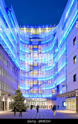 Neue BBC östliche Erweiterung Gebäude neben original Broadcasting House beleuchtet mit blauer Beleuchtung mit Weihnachtsbaum im Innenhof, zum BBC Eingang Stockfoto