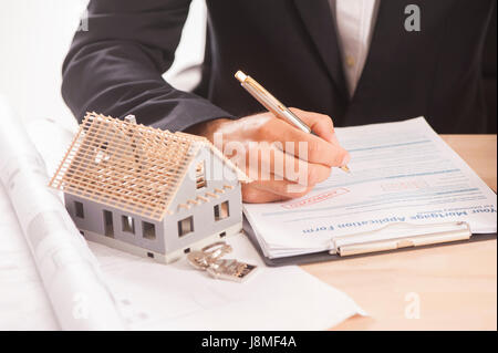Ein Geschäftsmann eine Hypothek Unterzeichnung Kaufvertrag für ein neues Haus Stockfoto