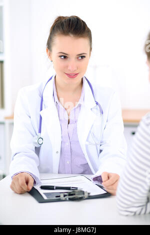 Junge Ärztin hören Patientengeschichte aufmerksam. Medizin- und Health-Care-Konzept. Stockfoto