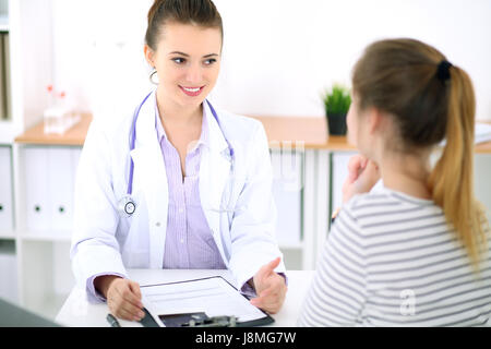 Junge Ärztin hören Patientengeschichte aufmerksam. Medizin- und Health-Care-Konzept. Stockfoto