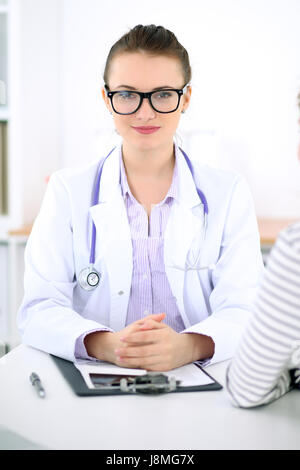 Junge Ärztin hören Patientengeschichte aufmerksam. Medizin- und Health-Care-Konzept. Stockfoto