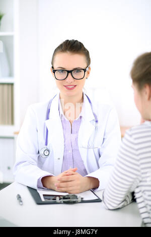 Junge Ärztin hören Patientengeschichte aufmerksam. Medizin- und Health-Care-Konzept. Stockfoto