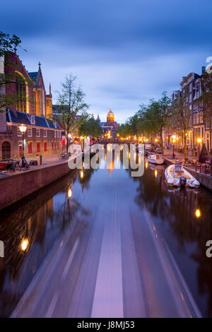 Blick auf Amsterdam den Kanal in das Rotlichtviertel in der Abenddämmerung. Stockfoto