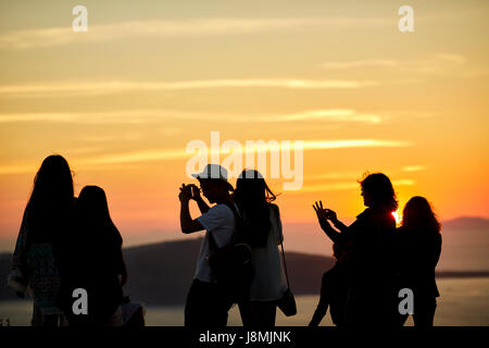 Vulkanische griechische Insel Santorin eine der Kykladen im Ägäischen Meer. Fira Islands Hauptstadt Touristen fotografieren Silhouette gegen th Stockfoto