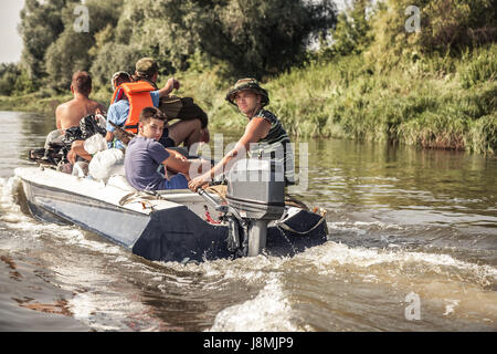 Gruppe von Männern Segeln Motorboot Fluss nach der Jagd-Camp während der Jagdsaison Stockfoto