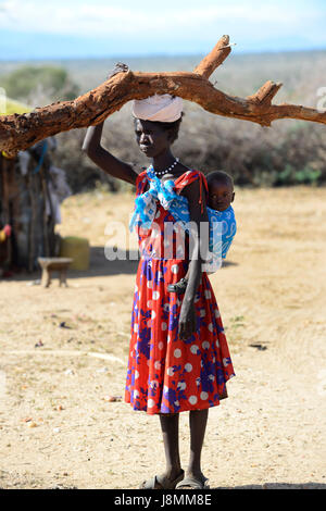 Ein turkana Frau, die ein großes Protokoll Holz auf den Kopf. Stockfoto