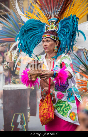 Mitglied des Xiuhcoatl Danza Azteca mit Angebot des Feuers während der Zeremonie im Karnevalstreiben in San Franciscos Mission District. Stockfoto