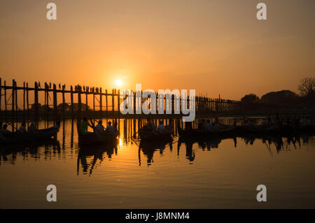 Silhouetten von Touristen in Boote bewundern U Bein Brücke über den Taungthaman-See bei Sonnenuntergang, in Amarapura, Mandalay, Myanmar Stockfoto