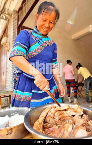 Nanning, China autonomen Region Guangxi Zhuang. 28. Mai 2017. Eine Frau der Volksgruppe der Zhuang bereitet Zutaten, um eine große kissenförmig "Mytisches" bei Luobo Township in Wuming Bezirk Nanning, Süd-China Autonome Region Guangxi Zhuang, 28. Mai 2017. Die kissenförmig "Mytisches" in Luobo besteht aus Klebreis, Gram und Fleisch. Bildnachweis: Pan Huaqing/Xinhua/Alamy Live-Nachrichten Stockfoto