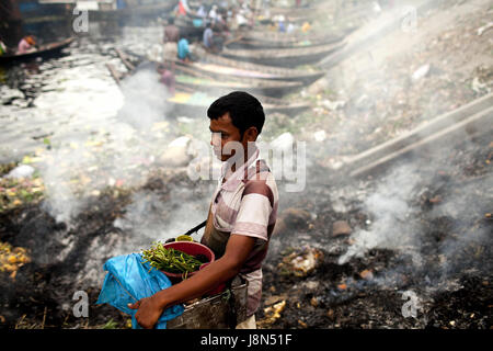 Dhaka, Dhaka, Bangladesh. 29. Mai 2017. 29. Mai 2017 - Dhaka, Bangladesch '' "eine Zigarette Anbieter neben der Abfall Verbrennung dumps Bereich Herstellung von Rauch und giftige Verunreinigung an der Seite von dem Fluss Buriganga, Dhaka. Laut der Weltgesundheitsorganisation (WHO) globale städtische Luftverschmutzung stieg um 8 Prozent zwischen 2008 und 2013. Mehr als 80 Prozent der Menschen leben in städtischen Gebieten, die Luftverschmutzung zu überwachen sind ausgesetzt Luft Qualitätsstufen, die (der) überschreiten Grenzen, bedrohliche Leben, Produktivität und Volkswirtschaften. Bildnachweis: K M Asad/ZUMA Draht/Alamy Live-Nachrichten Stockfoto