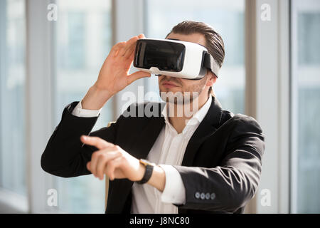 Mann trägt VR Kopfhörer und deutete auf die Luft Stockfoto