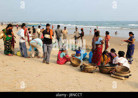 PURI, Indien - 19. Dezember 2009: armen indischen Fischer zusammen mit Familien warten am Strand für die Boote, die vom Fischfang zurückkehren Stockfoto