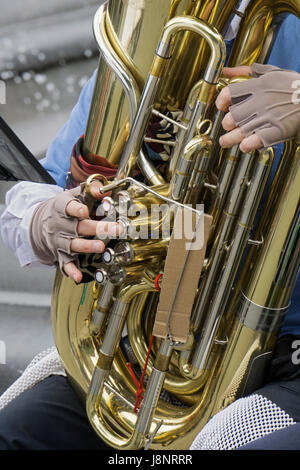 Nahaufnahme Foto der behandschuhten Hände ein Straßenmusikant Musiker in der Band Uni spielt die Tuba im Washington Square Park in Greenwich Village, New York City Stockfoto