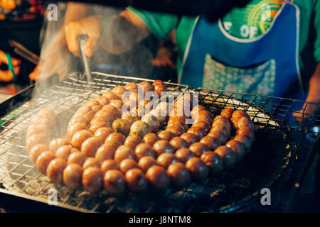 CHIANG MAI, THAILAND - 21 AUGUST: Man kocht Frikadellen auf dem Grill am Sonntagsmarkt (Walking Street) am 21. August 2016 in Chiang Mai, Thailand. Stockfoto