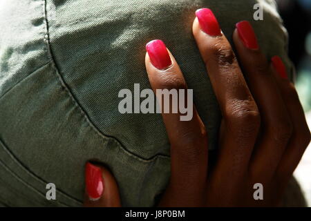 Hand der schwarze Frau mit roten Nägeln Stockfoto