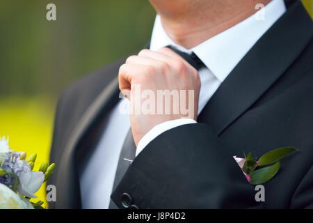 Ein gutes Geschäft suchen. Bild des Jünglings in festlich gekleidet Anpassung seine Krawatte abgeschnitten Stockfoto