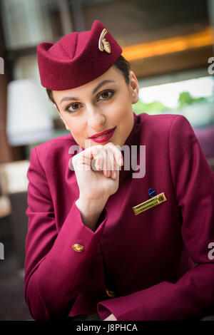 Attraktive Dame, Katar Flugbegleiter Flugbegleiter auf Zwischenstopp am Flughafen London Heathrow auf nächsten Flug nach Doha Katar. Stockfoto