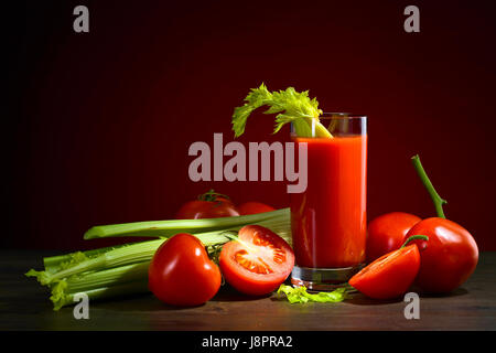 Tomatensaft mit Tomaten und Sellerie-sticks auf einem Holztisch Stockfoto