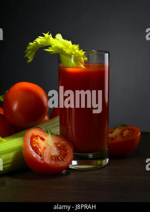 Tomatensaft mit Tomaten und Sellerie-sticks auf einem Holztisch Stockfoto