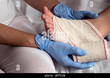 Nahaufnahme einer Krankenschwester Bandage auf Patientenfußes binden Stockfoto