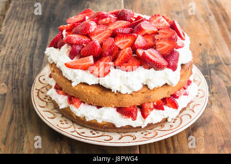 Erdbeeren-Käsekuchen auf rustikalen Holztisch. Stockfoto