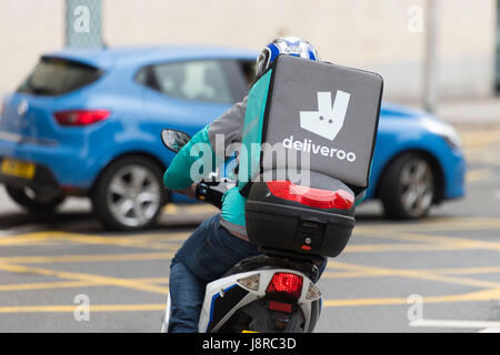 Ein Deliveroo Reiter auf einem Moped machen einen Lebensmittel-Lieferservice in Cardiff, Wales, UK. Stockfoto