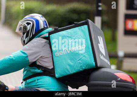 Ein Deliveroo Reiter auf einem Moped machen einen Lebensmittel-Lieferservice in Cardiff, Wales, UK. Stockfoto