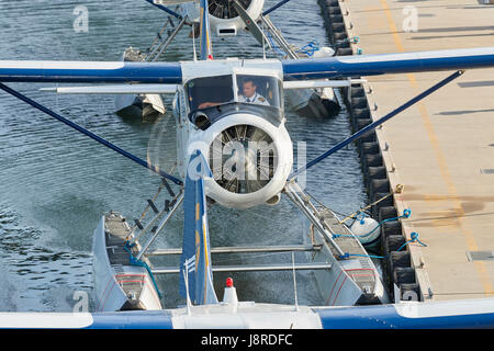 Pilot läuft der Motor auf Harbour Air Wasserflugzeuge Vintage de Havilland Canada DHC-2 Beaver Wasserflugzeug vertäut am Vancouver Harbour Flight Center, Kanada. Stockfoto