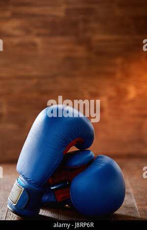 Paar zwei rote Boxhandschuhe liegen auf Holztisch Holz Hintergrund. Stockfoto