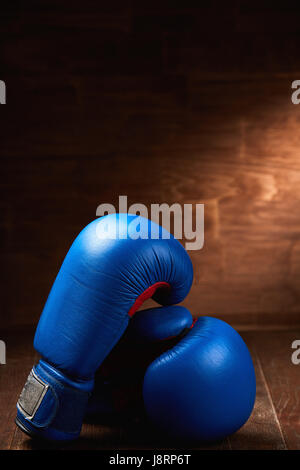 Paar zwei rote Boxhandschuhe liegen auf Holztisch Holz Hintergrund. Stockfoto