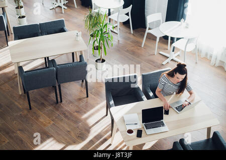 Schuss von ein mittlere gealterte Frau machen Anruf und arbeiten am Laptop sitzen im Café. Stockfoto