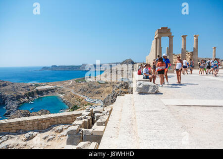 LINDOS, Rhodos, Griechenland - 3. September 2015: Menschen, die Besichtigung der Ruinen von einem dorischen Tempel der Athena Lindia auf der Akropolis von Lindos, Beobachtung Stockfoto