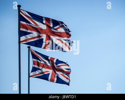 Zwei Union Jack-Flaggen, Hintergrundbeleuchtung vor blauem Himmel Stockfoto