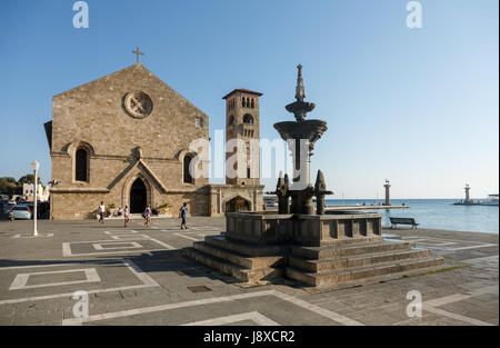 Rhodos, Griechenland - 3. September 2015: Passanten in der Nähe von Brunnen und Evangelismos-Kirche (auch genannt die Kirche der Mariä Verkündigung) in Mandraki Har Stockfoto