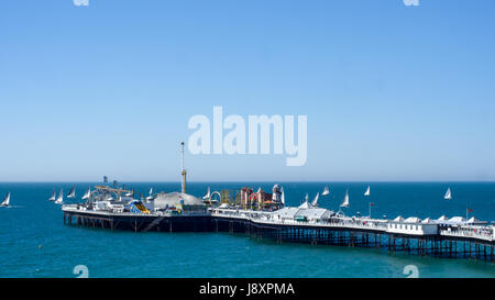 Segelboote in einer Regatta rund um den viktorianischen Pier von Brighton, Südengland Stockfoto