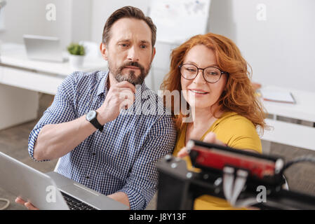 Ernsthafte nachdenklicher Mann, Blick auf die 3d Drucker Stockfoto