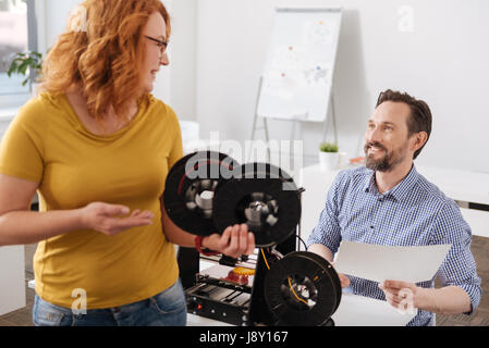 Freudige hübsche Frau hält mehrere Filament-Spulen Stockfoto