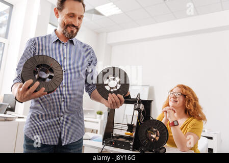 Betrachtet man die Fäden Spulen positive glücklich Stockfoto