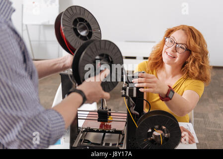 Freuen uns positive Frau, die die Filament-Spulen Stockfoto