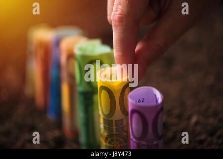 Euro Geld, landwirtschaftliche Konzeptbild mit der Hand pflücken EU Geldschein aus fruchtbarem Boden Boden ernten Stockfoto