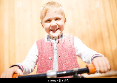 Foto eines jungen mit Zyklus in der Nähe von Holzwand Stockfoto