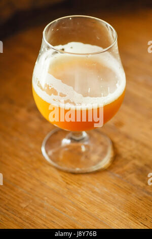 Glas Weizen Bier stehend auf einem Holzfass in einer Brauerei Stockfoto