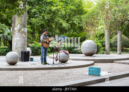 Guilin, China.  Straßenmusiker spielen Gitarre auf Stadt Bürgersteig. Stockfoto