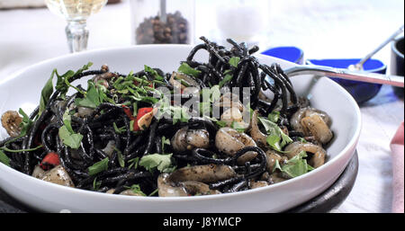 Blick auf leckere schwarze Pasta mit Kalamari (Tintenfisch) und Tinte Stockfoto