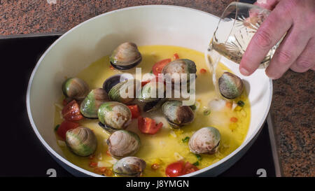 Strömenden Weisswein beim Kochen leckere Spaghetti Alle Vongole (Venusmuscheln) Stockfoto