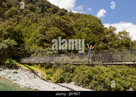 Frau auf dem Swinging Bridge auf dem hollyford track Neuseeland Stockfoto